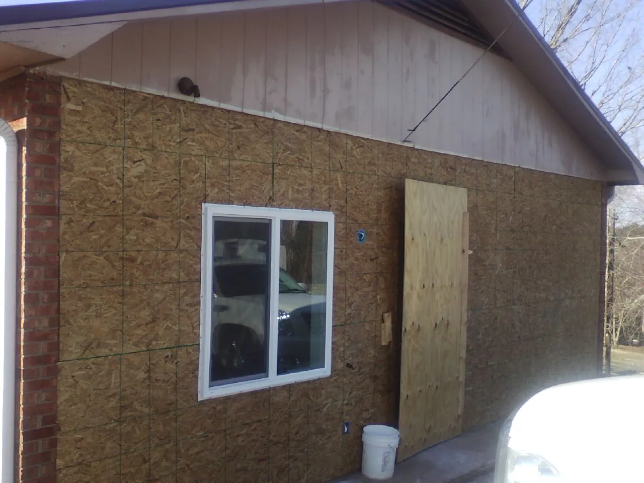 OSB sheathing on a garage addition wall before siding in Sterling